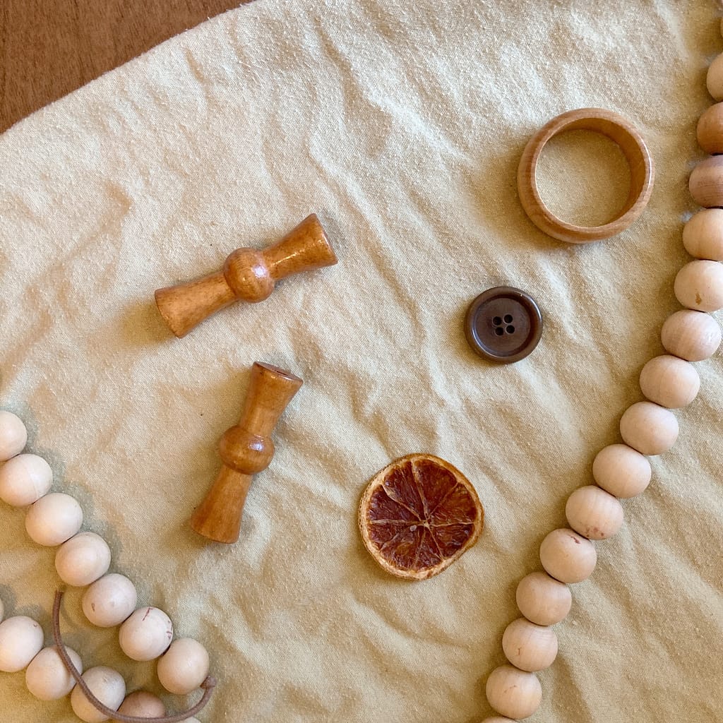 loose parts such as buttons, macrame wood beads and orange slices. 